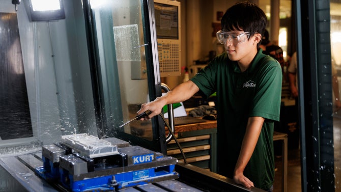 Mechanical engineering student Ethan Chang machines the CubeSat rail fixture using a milling macing inside the Mustang 60 Machine Shop.
