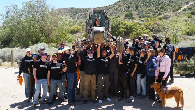 The Baja SAE team hoists their vehicle after completing their dynamic events in Gorman, California