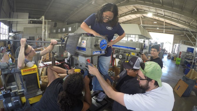 students cleaning machine in hangar