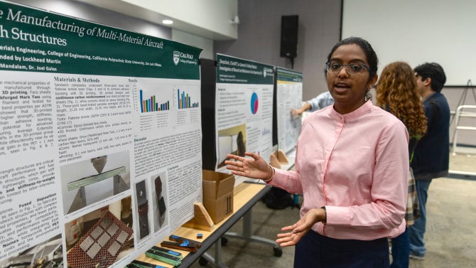 student giving surp presentation with posterboard displayed