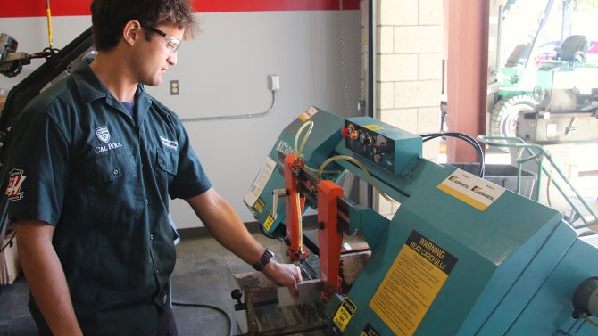 Manufacturing engineering senior Will Graham uses a horizontal band saw to cut aluminum stock in Cal Poly’s Haas Advanced Machining Lab.