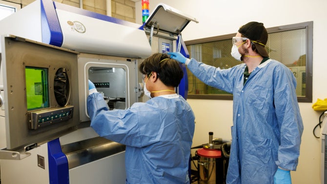 Graduate and undergraduate students in Additive Manufacturing class use a powder bed fusion 3D printer to create projects from stainless steel powder.