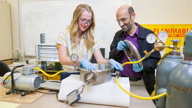 Civil and environmental engineering student Corinne Watson (left) works with assistant professor Amro El Badawy on carbon capture research.