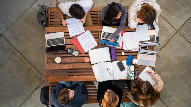 Students study at the tables outside of the Faculty Offices East building, overhead view.