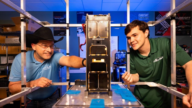 professor works with student on cubesat satellite