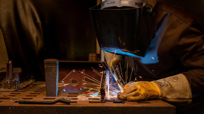 student working on senior project in machine lab