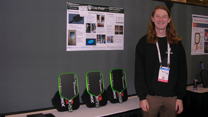 Mechanical engineering graduate Donovan Furtado stands with the poster and three carbon fiber paddles that earned first place in SAMPE’s inaugural Student Pickleball Paddle Design Competition. 