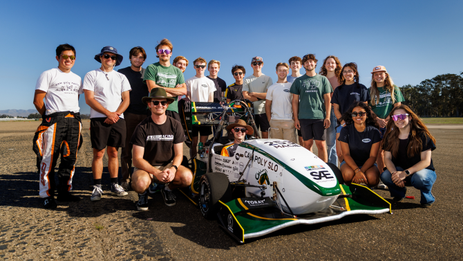 Students stand with Cal Poly Racing's Formula car during a practice run