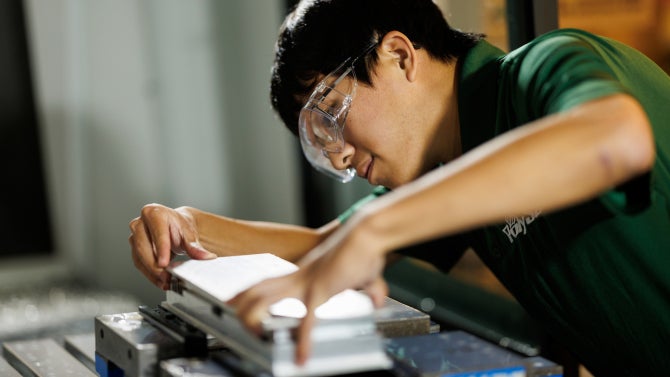 Mechanical engineering student Ethan Chang machines the CubeSat rail fixture using a milling machine inside the Mustang 60 Machine Shop.