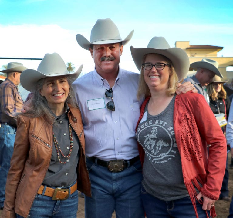 Two woman and a man in cowboy hats.