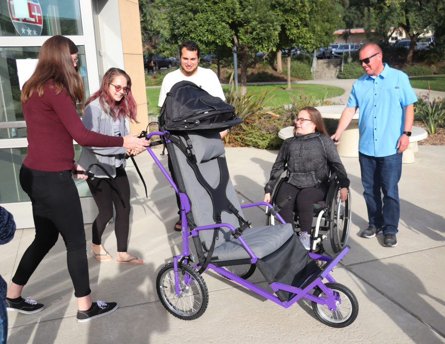 Mechanical engineering senior project students present a new jogger to Katie Robionson