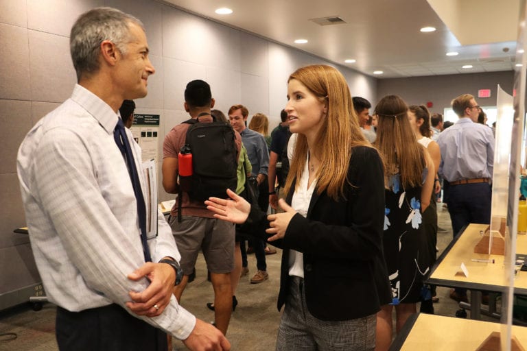 SURP student interacting with faculty during Symposium event