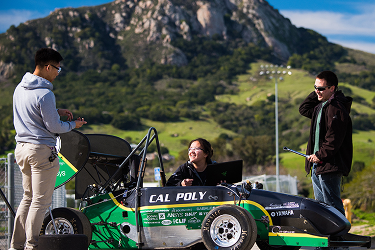 FSAE students with formula car outdoors with Bishop's Peak in the background