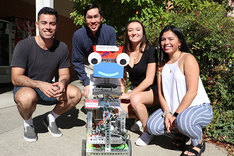 Four students around robot