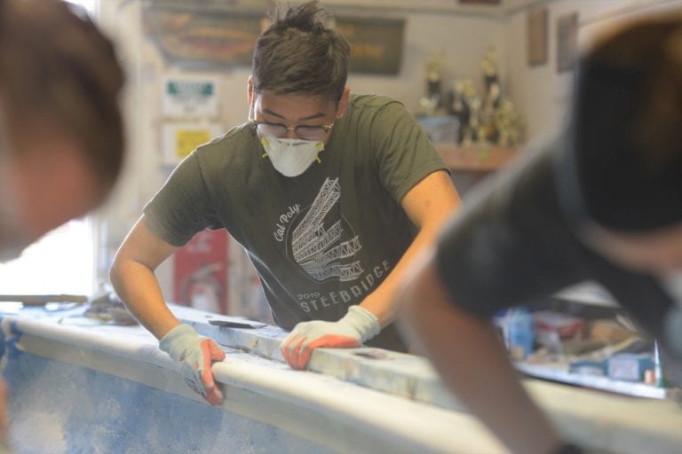 Student Jerry Ding sanding concrete canoe project