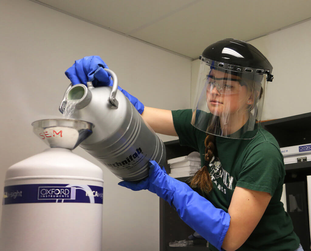 Materials Engineering student Carolina Cleland pours liquid nitrogen into a scanning electron microsope (SEM)