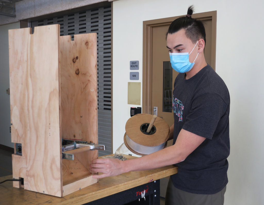 Kyle Chuang works on his team's prototype of a kitting workspace. 
