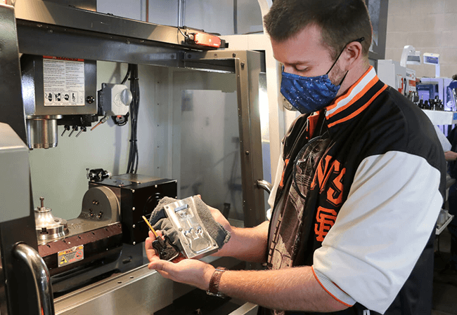 Manufacturing engineering student Jason Pagendarm holds the ejection mold and screwdriver he designed and manufactured for IME 450