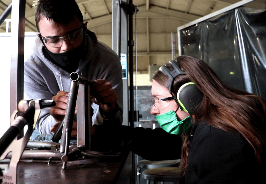 Members of Cal Poly's Baja Racing team work on a chassis. 