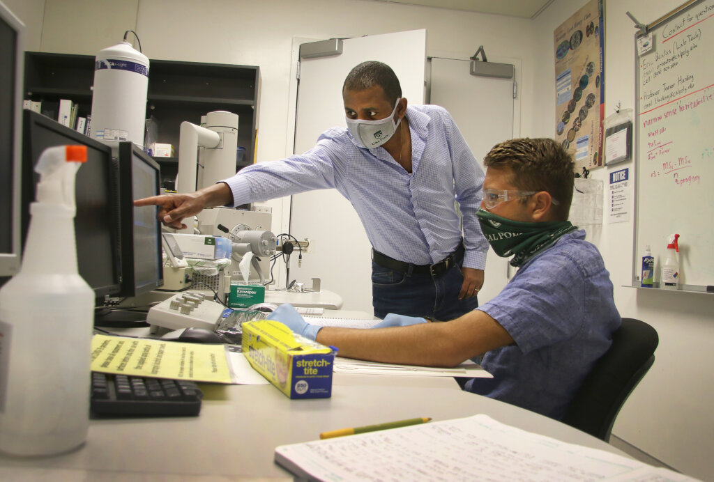 Materials engineering lecturer Desalegn Alemu Mengistie works with MATE student Vincent Guarino in a lab.