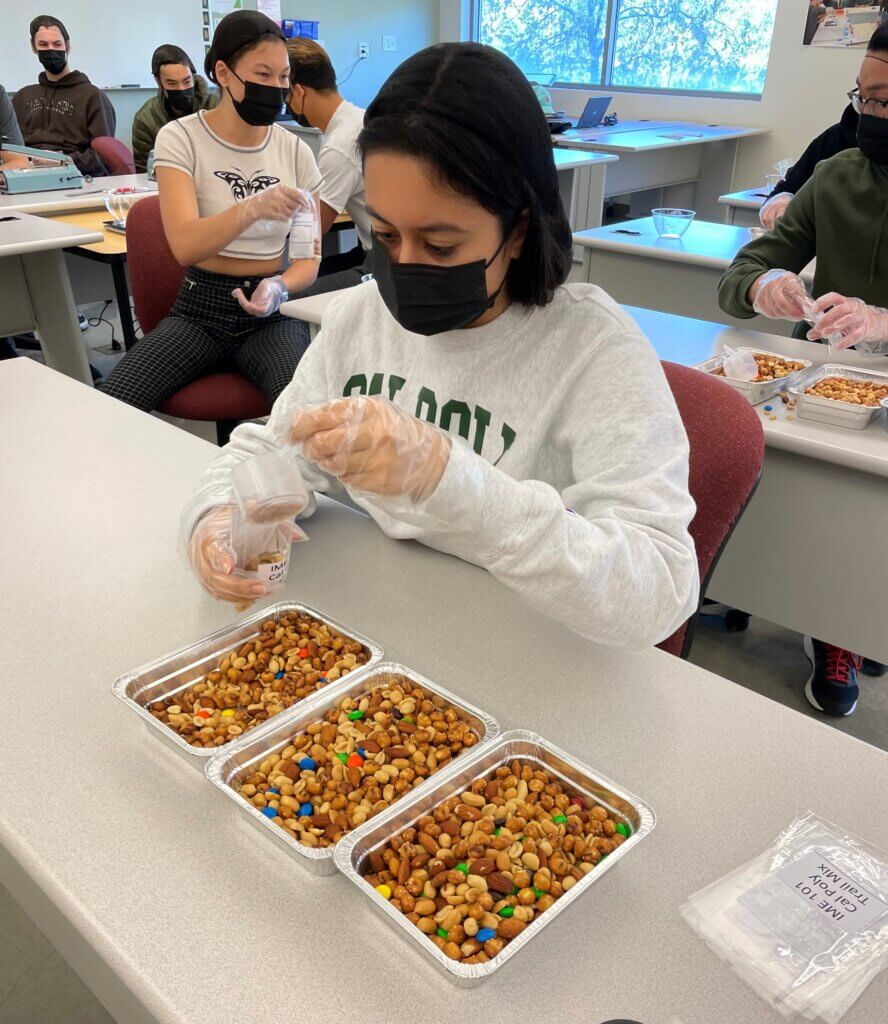 Students in IME 101 plannedm created and improved a process to crreate trail mix packets for the Cal poly Food Bank.