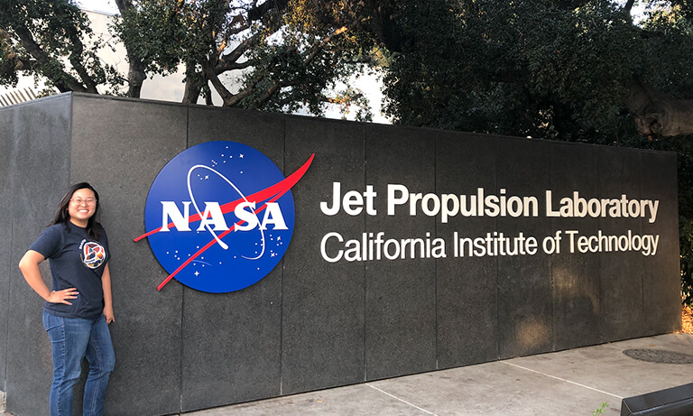 Woman standing on front of JPL sign.