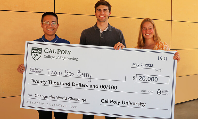 Three students holding large check