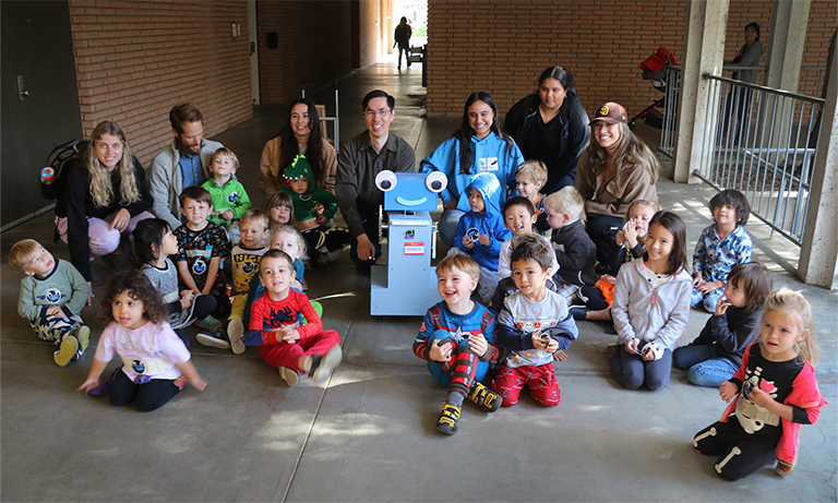 Computer Science Professor John Seng's robot Herbie poses with pre-school students from the Cal Poly Children's Center on Monday, Oct. 31, 2022.