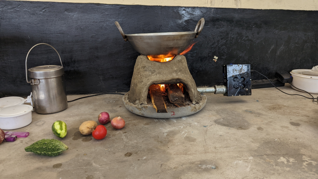 A traditional cookstove retrofitted with the Prakti Air device