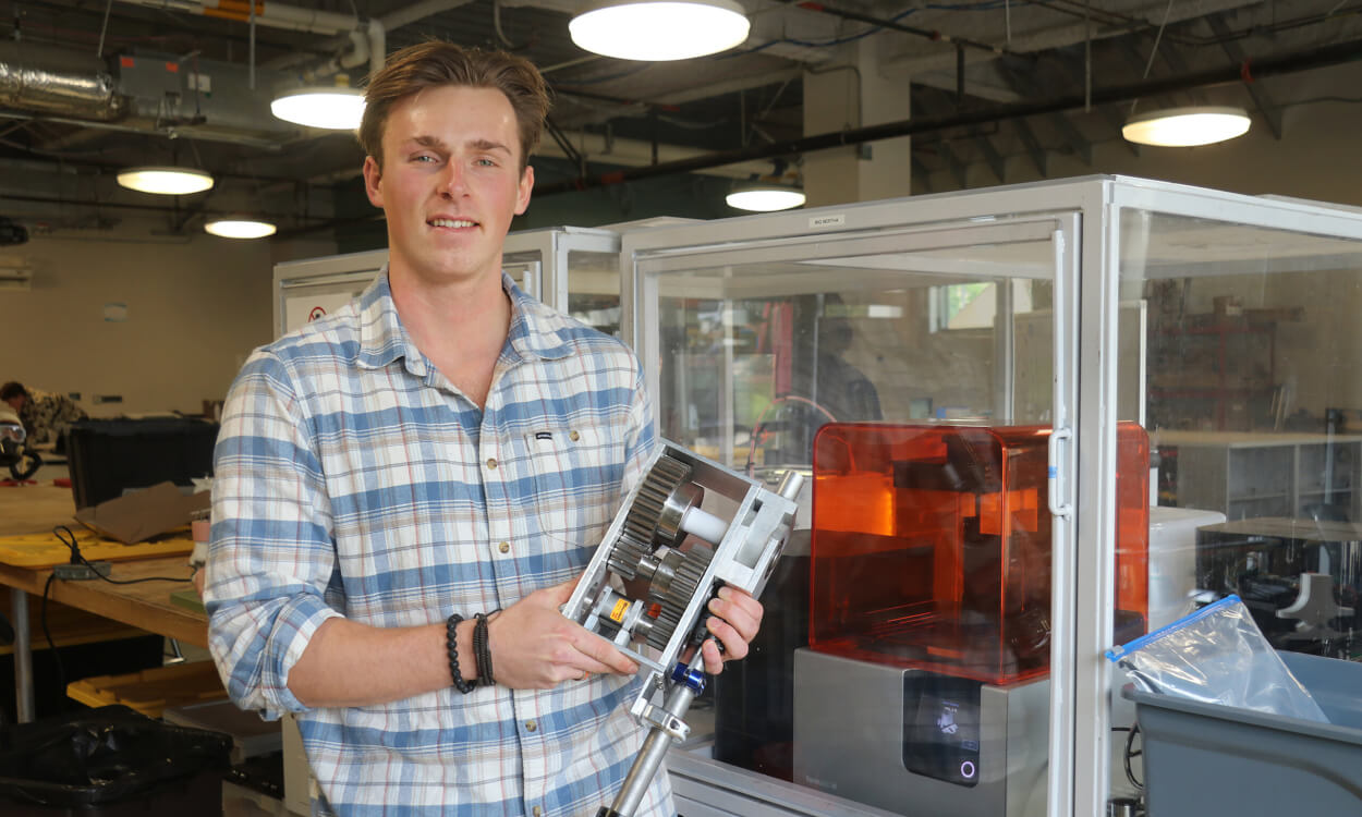 Biomedical engineering student Max Lewter holds up part of his exoskeleton project.