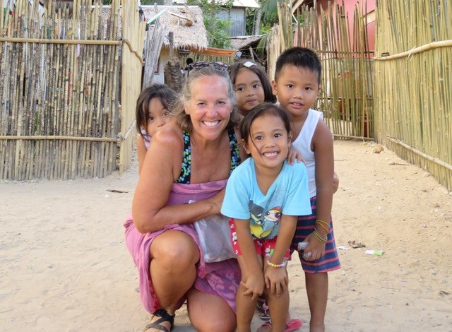 Alumna poses with children in the Philippines