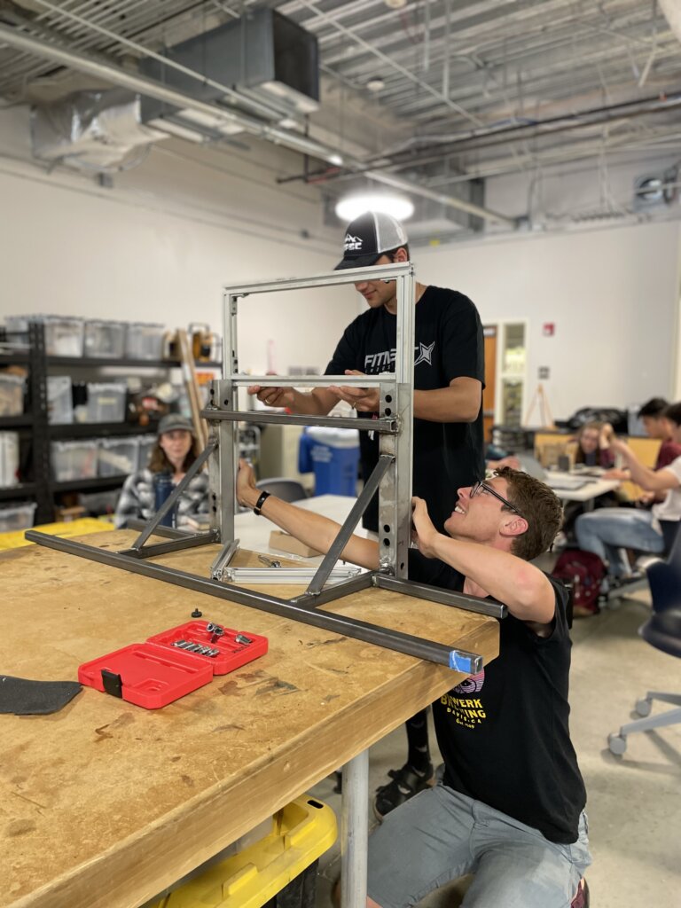 Two students assemble test stand for exoskeleton prototype