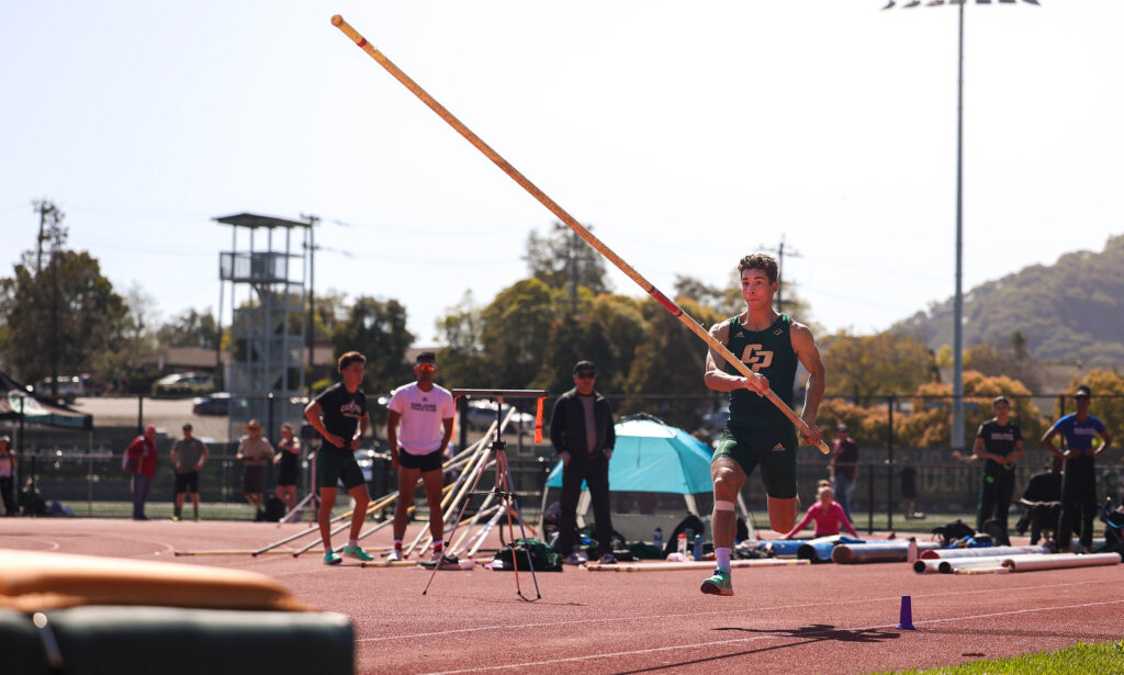 Student runs down the track in preparation for his pole vault jump
