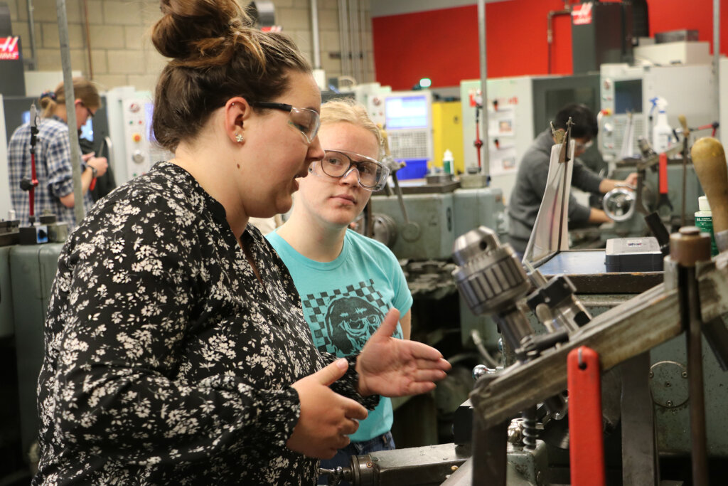 Teacher shows student the lathes in a lab