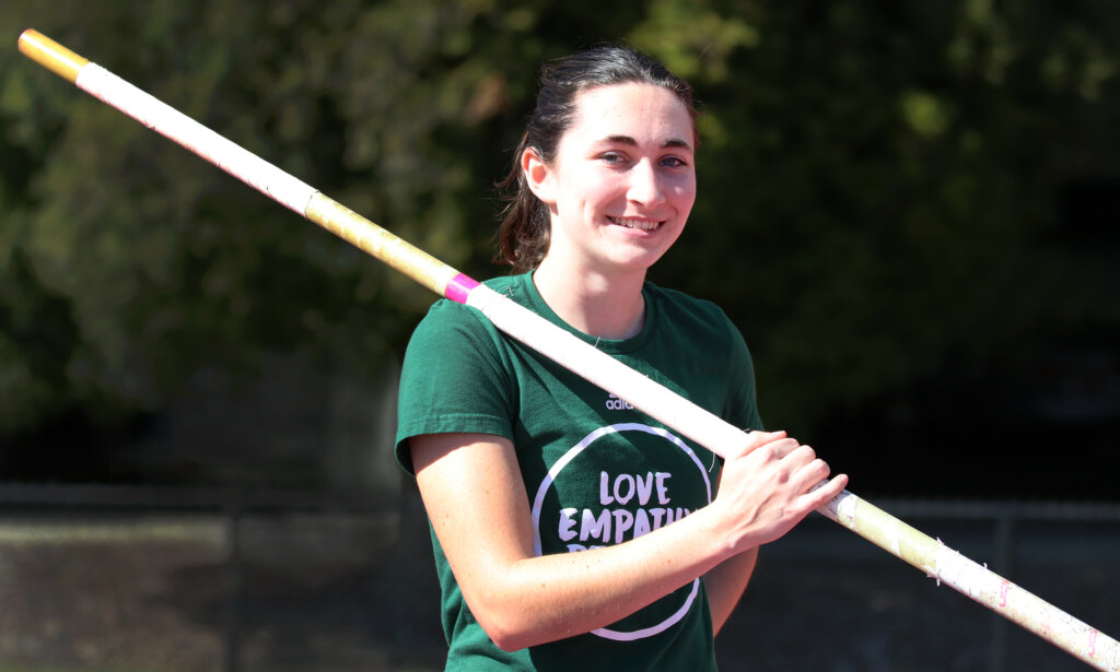 Student poses for photo with her pole for vaulting