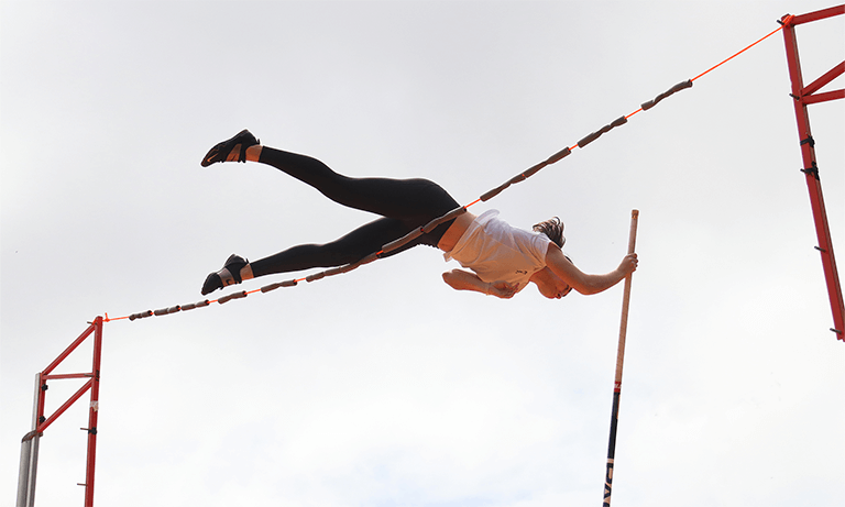 Student Lexi Evans pole vaulting for Cal Poly's track and field team
