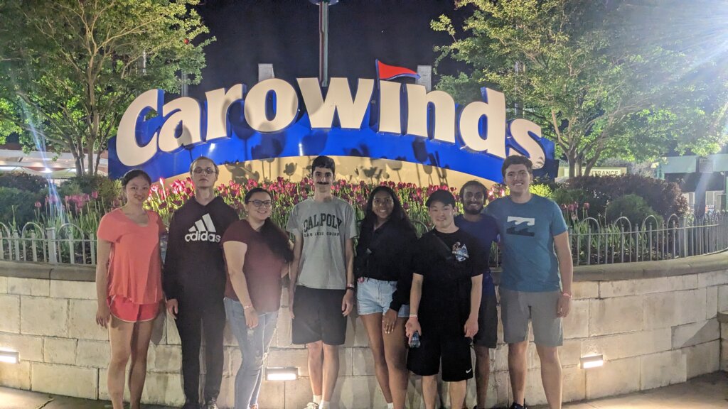 CAPED members stand in front of the Carowinds amusement park sign