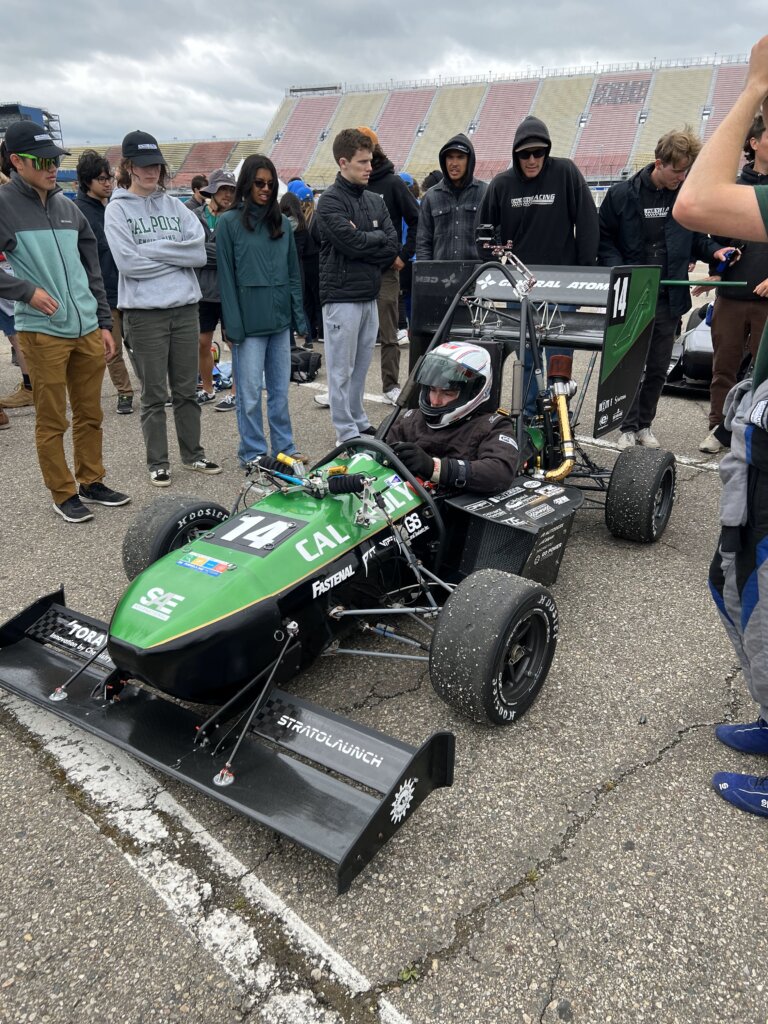 Student sits in race car, ready to compete