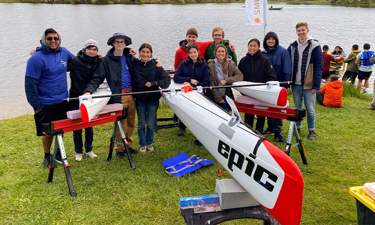 Cal Poly Solar Regatta Club members stand with their boat