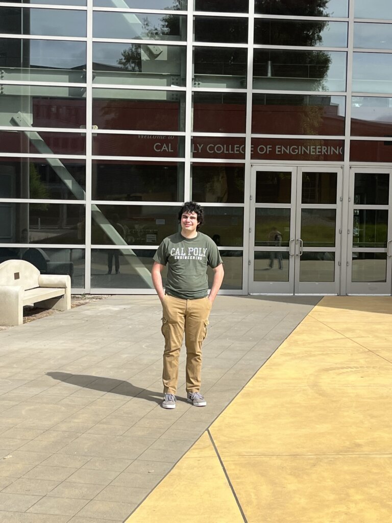Student stands in front of the College of Engineering building