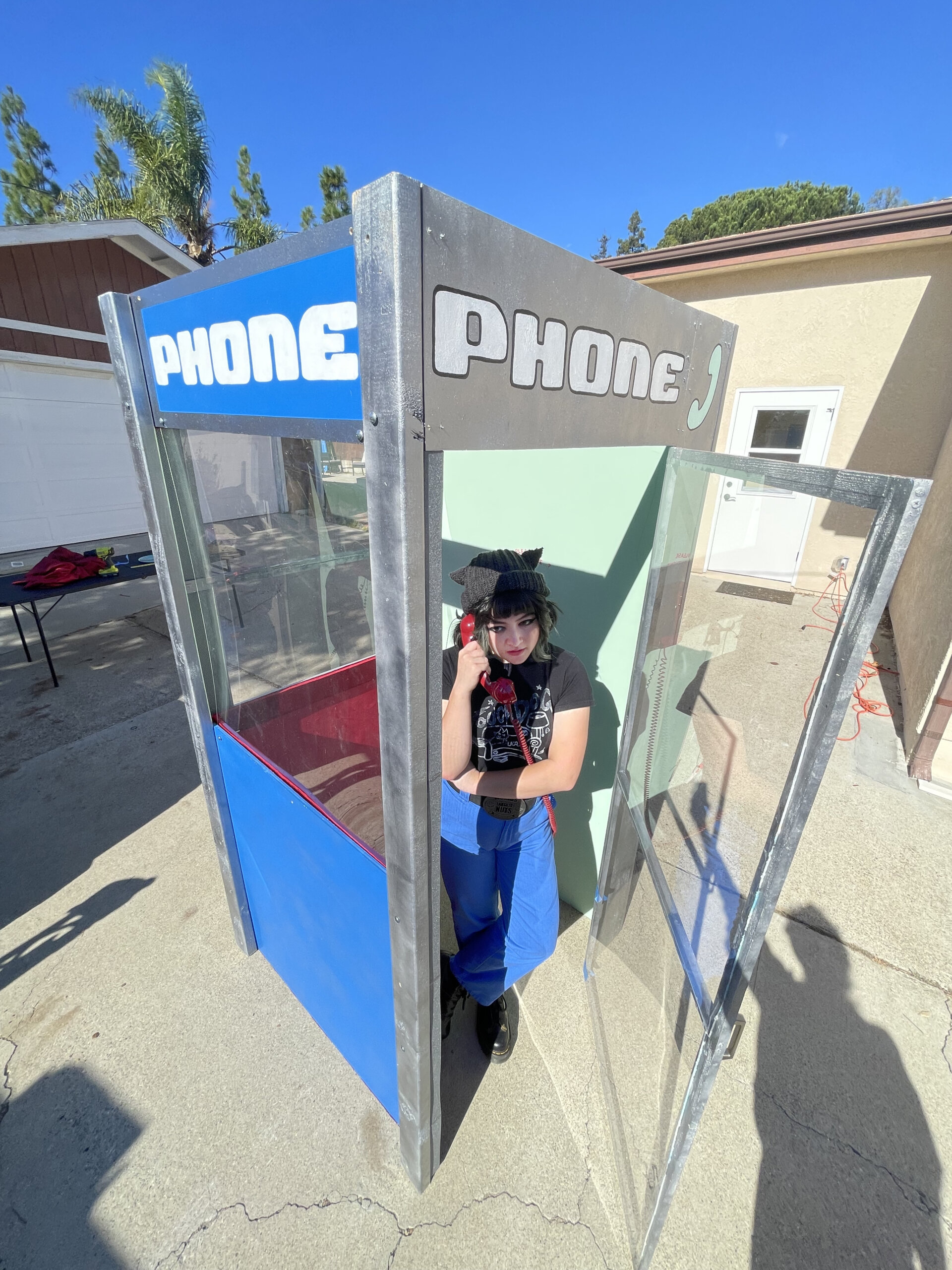 A band member is inside the phone booth she built for concerts