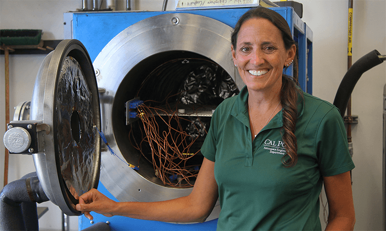 Woman standing in front of a thermal vacuum machine