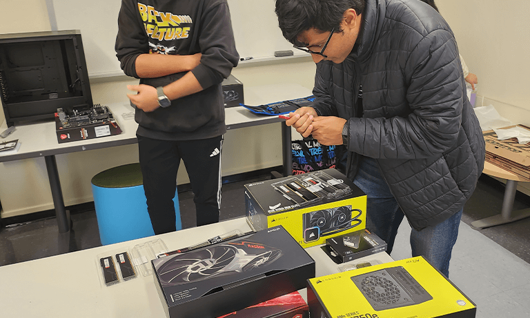 A student working on putting together computer parts