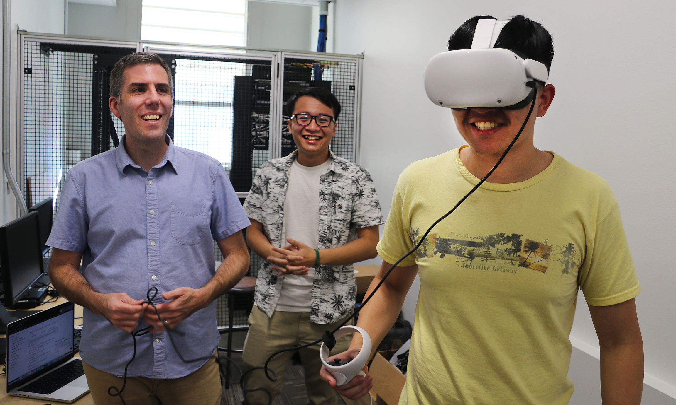 Professor Ventura aids two students as they use VR equipment in a lab at Cal Poly