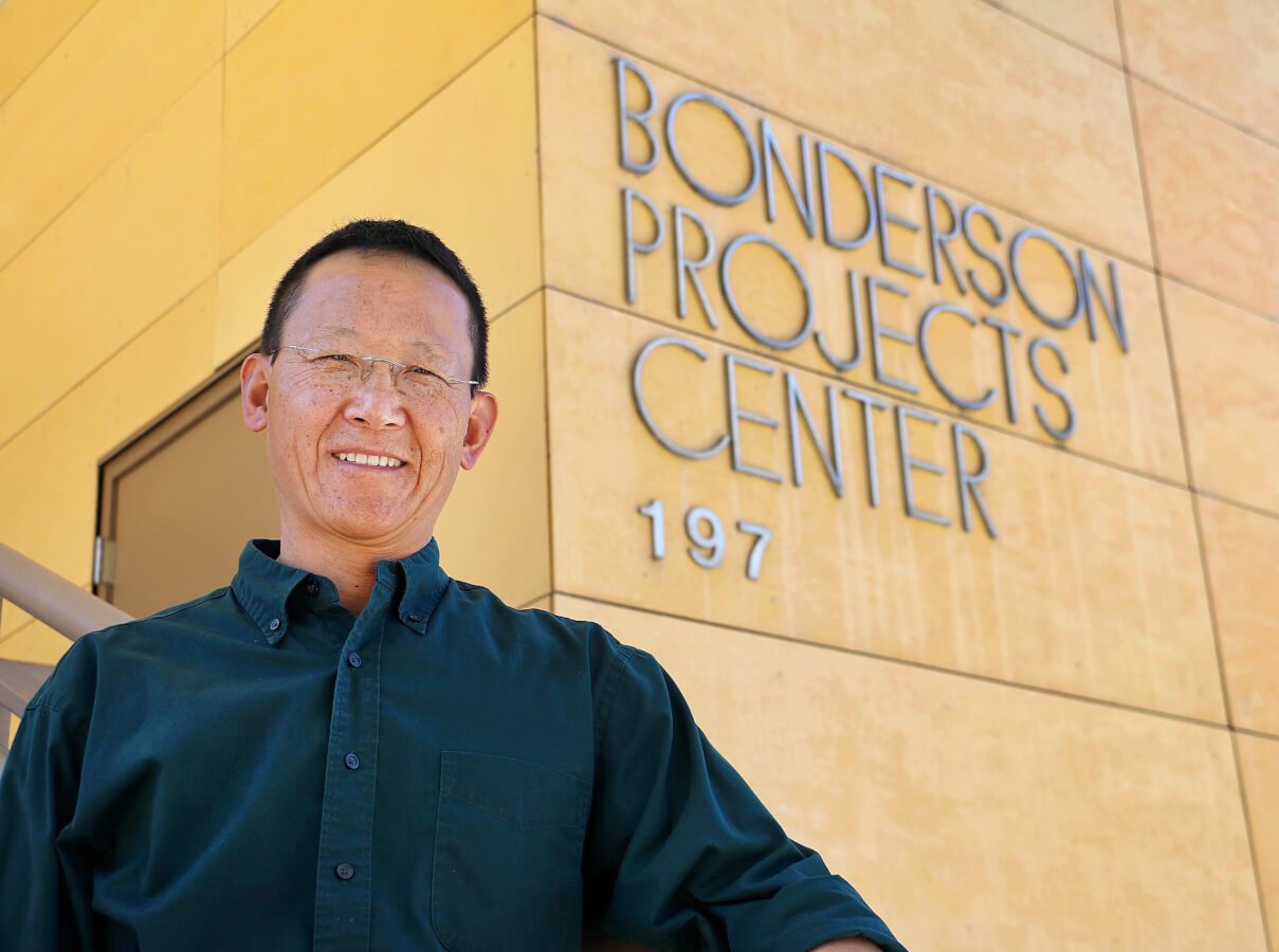 Professor John Chen stands in front of the Bonderson Project Center. He is pursuing research to help students thrive