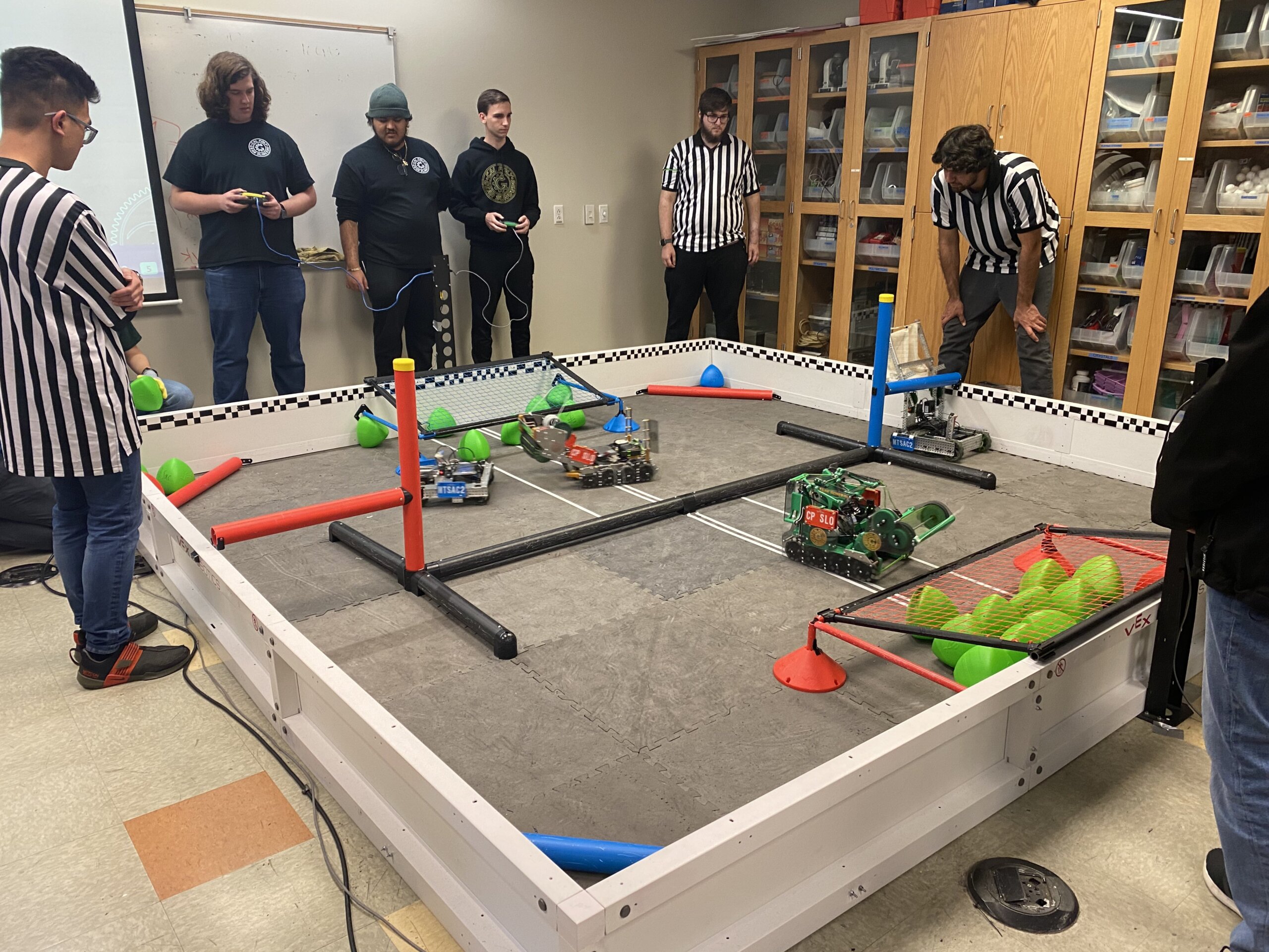Cal Poly's Gear Slingers compete with their robots at Mt. San Antonio College. They stand next to the match field as they control their robots in the driver-controlled part of the contest
