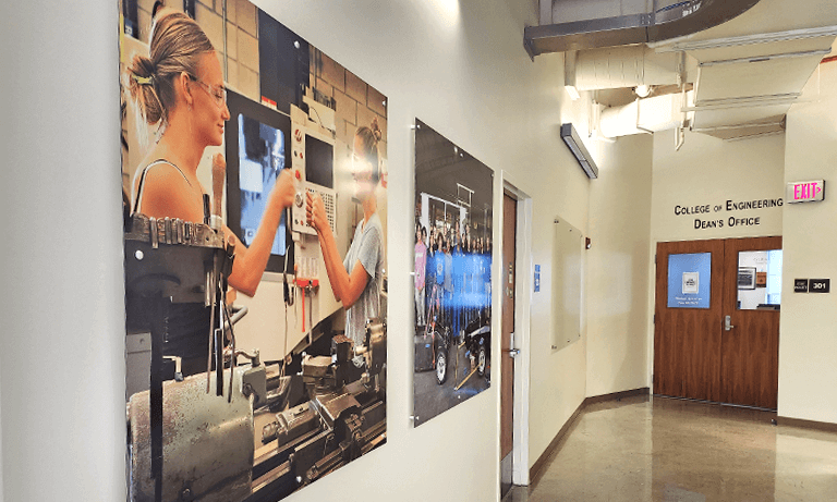 A hallway in the College of Engineering with large photographs on the walls depicting Learn by Doing, which is Cal Poly's motto
