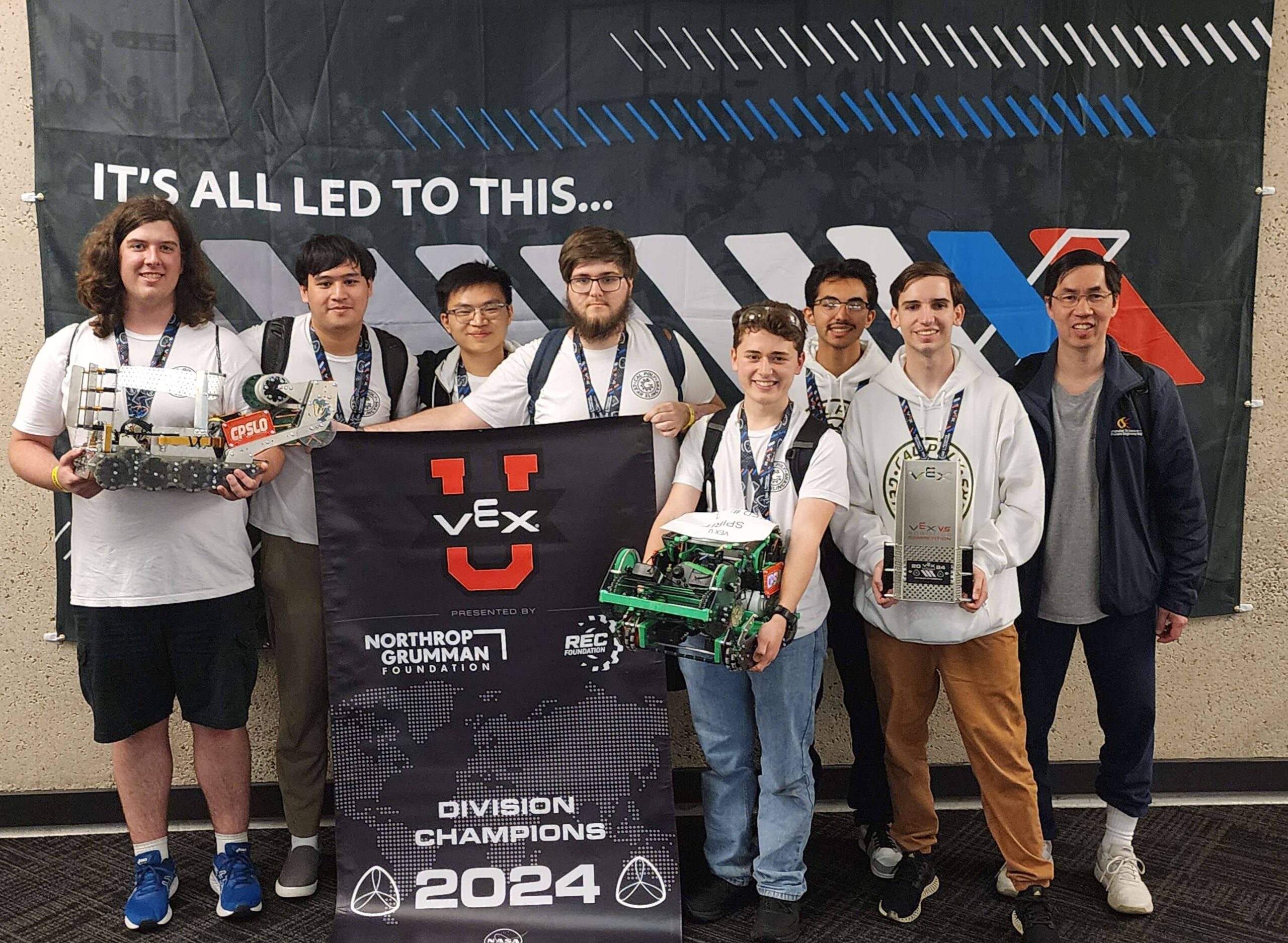 The Gear Slingers pose with their division championship banner, robots and trophy