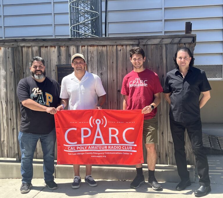 Electrical engineering professor and students stand with the CPARC banner