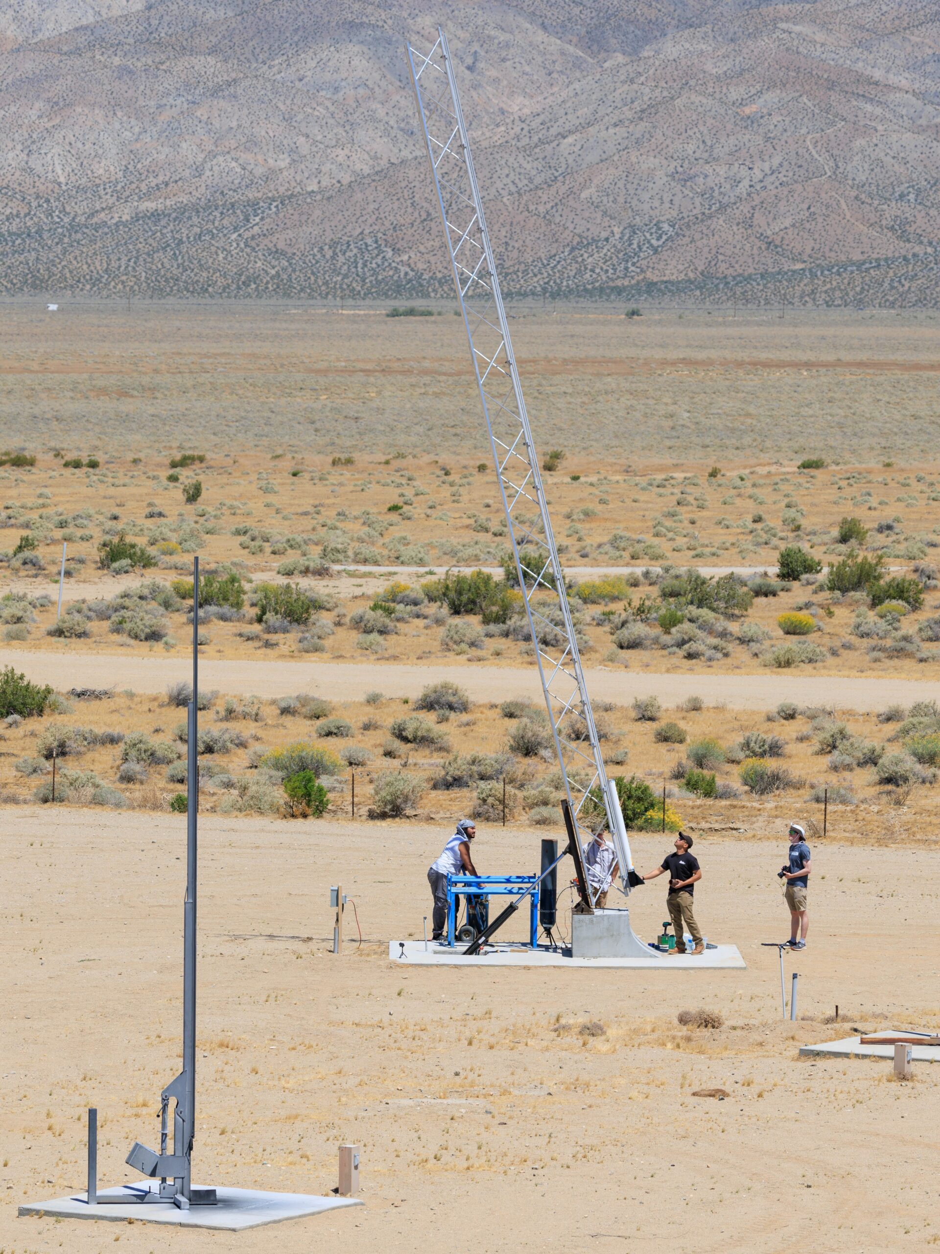 Let it Loose members raise their rocket on the launch rail in the Mojave Desert